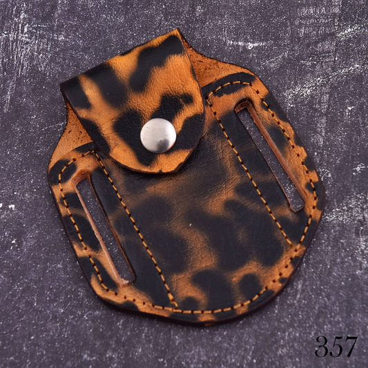Handmade brown and black leather knife sheath with snap closure and belt carry slots for folding knife storage