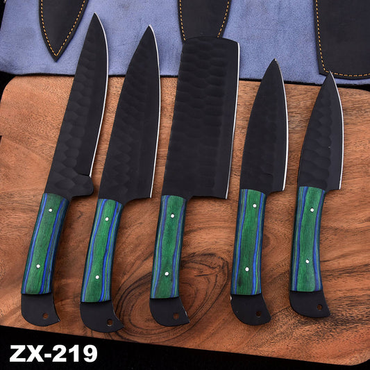 Five-piece handmade black chef knife set with green and blue wood handles and protective leather sheaths