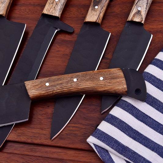 A set of large kitchen knives with dark steel blades and brown wood-grain handles, arranged diagonally on a dark wooden surface next to a blue and white striped cloth.