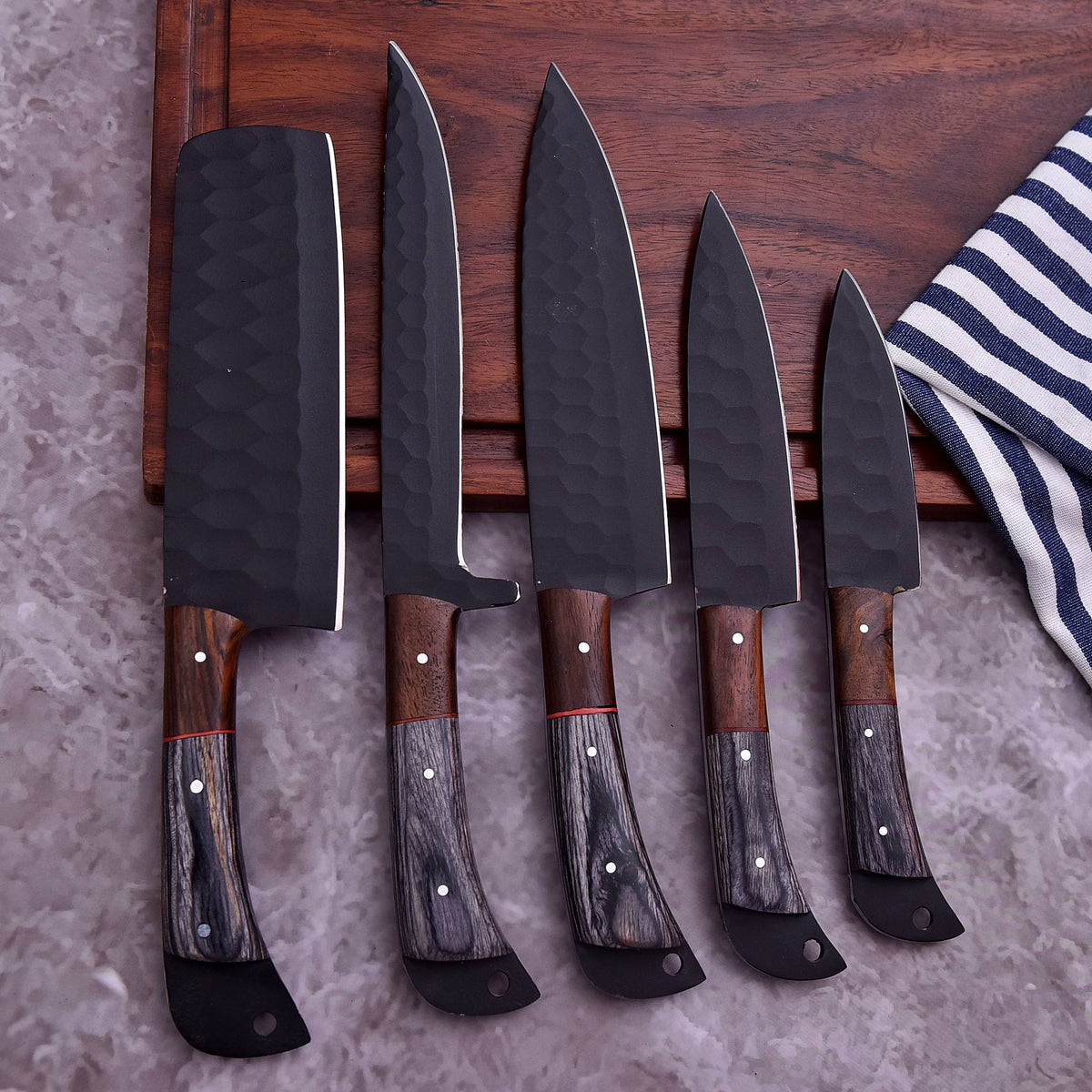 Set of knives with wooden handles on a wooden cutting board.