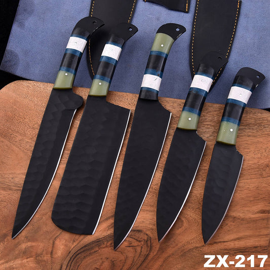 Five kitchen knives with black textured blades and green, blue, and black handles, arranged on a wooden cutting board with a blue fabric background and black sheaths. The text 'ZX-217' is visible in the bottom right corner.