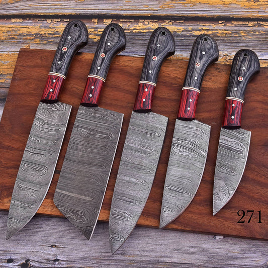 Five Damascus steel kitchen knives with dark wood handles and red ferrules, arranged diagonally on a wooden cutting board over a rustic wooden surface.