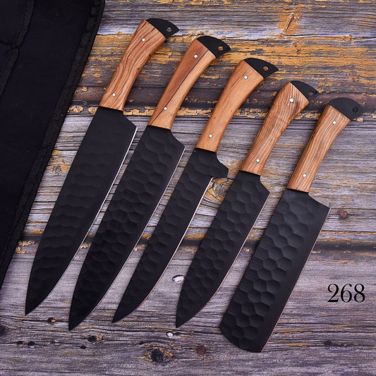 Five kitchen knives with hammered black blades and light brown wood handles are arranged diagonally on a rustic weathered wood surface next to a black knife sheath. The number 268 is printed in the bottom right corner.